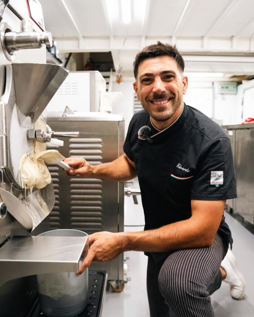 Edoardo Gori in his ice-cream maker's outfit, spatula in hand, in front of the ice-cream machine in his Ughissimo workshop in Bayonne