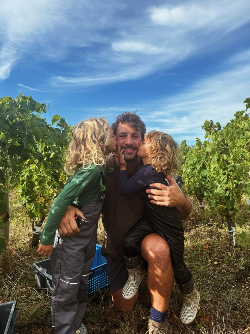 Rémi Lamerat in his vineyard, kissed by his two children